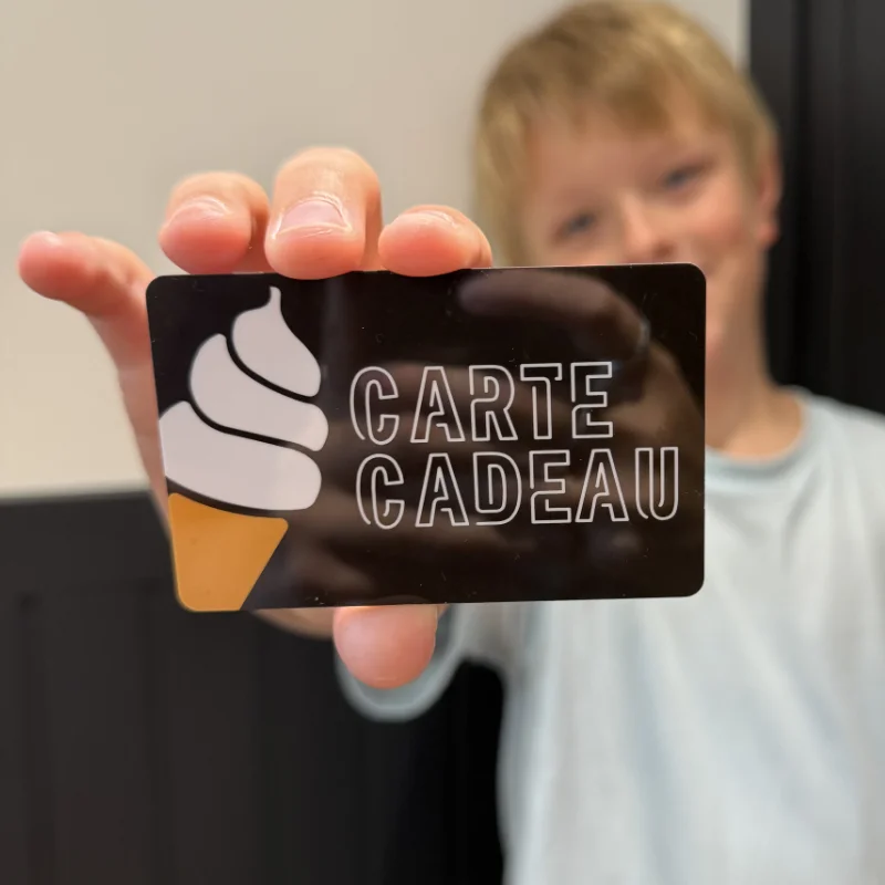 Un enfant tend une carte-cadeau Chic Choco-Latté