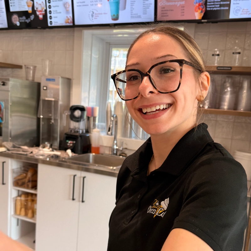Une employée souriante derrière le comptoir